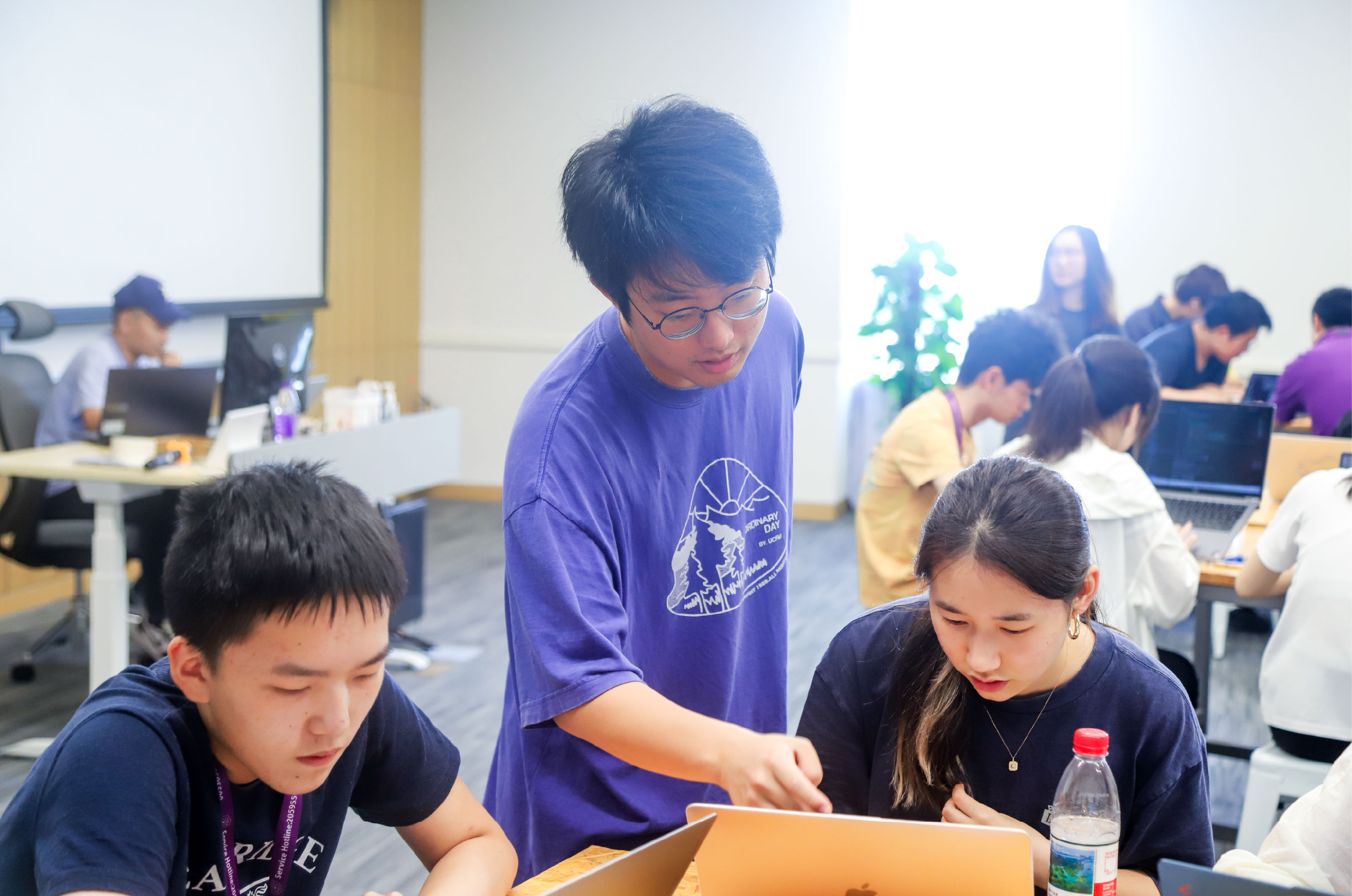 Yicheng (middle) coaching students on how to use Kiwi during the AI Summer School