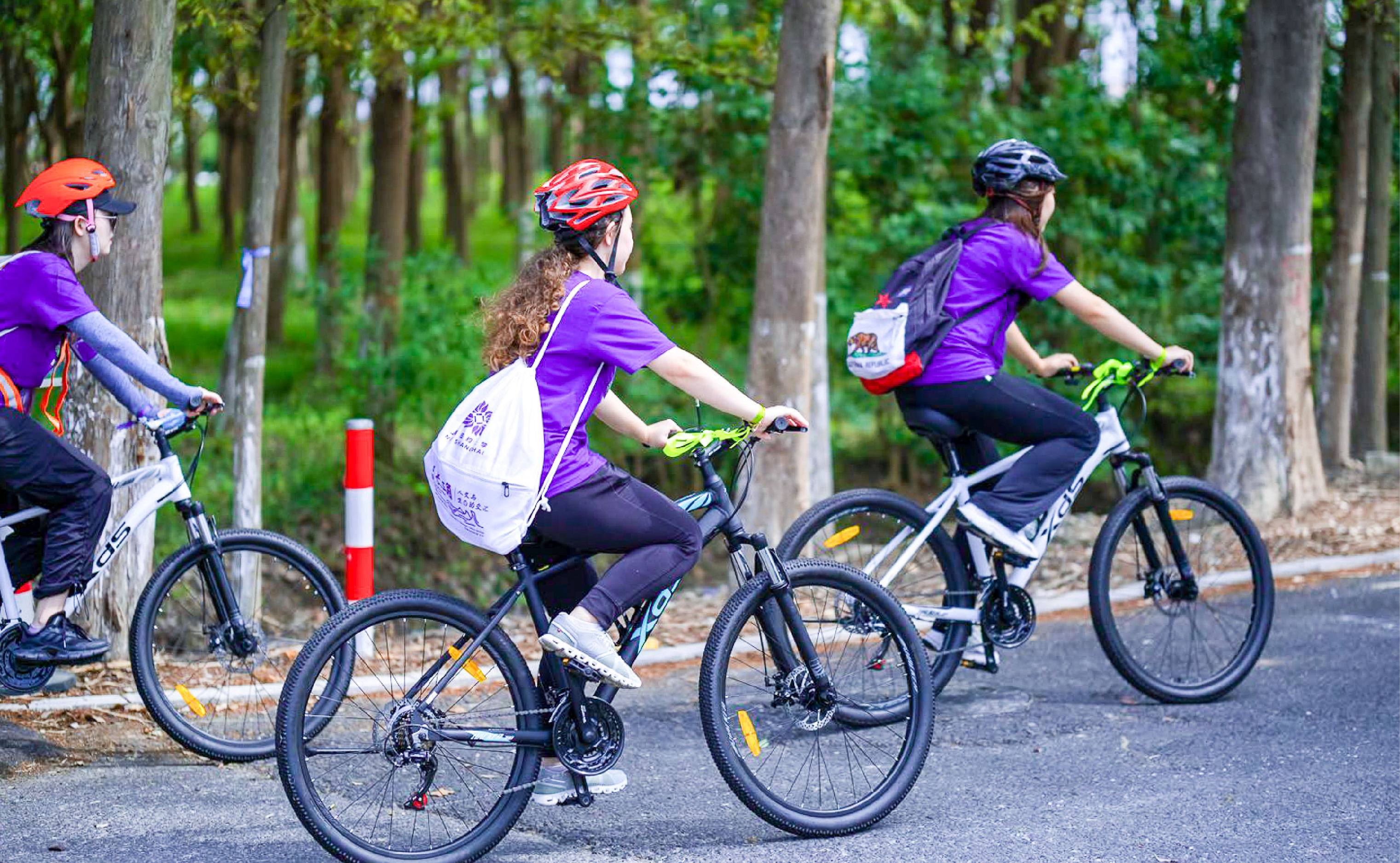 community members cycle along a tree lined path