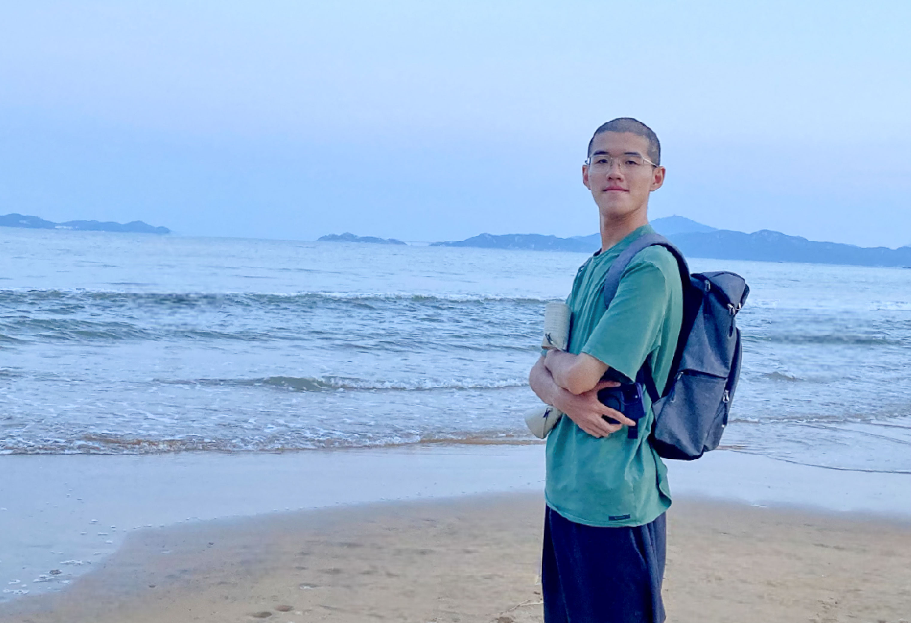 a student standing by the ocean