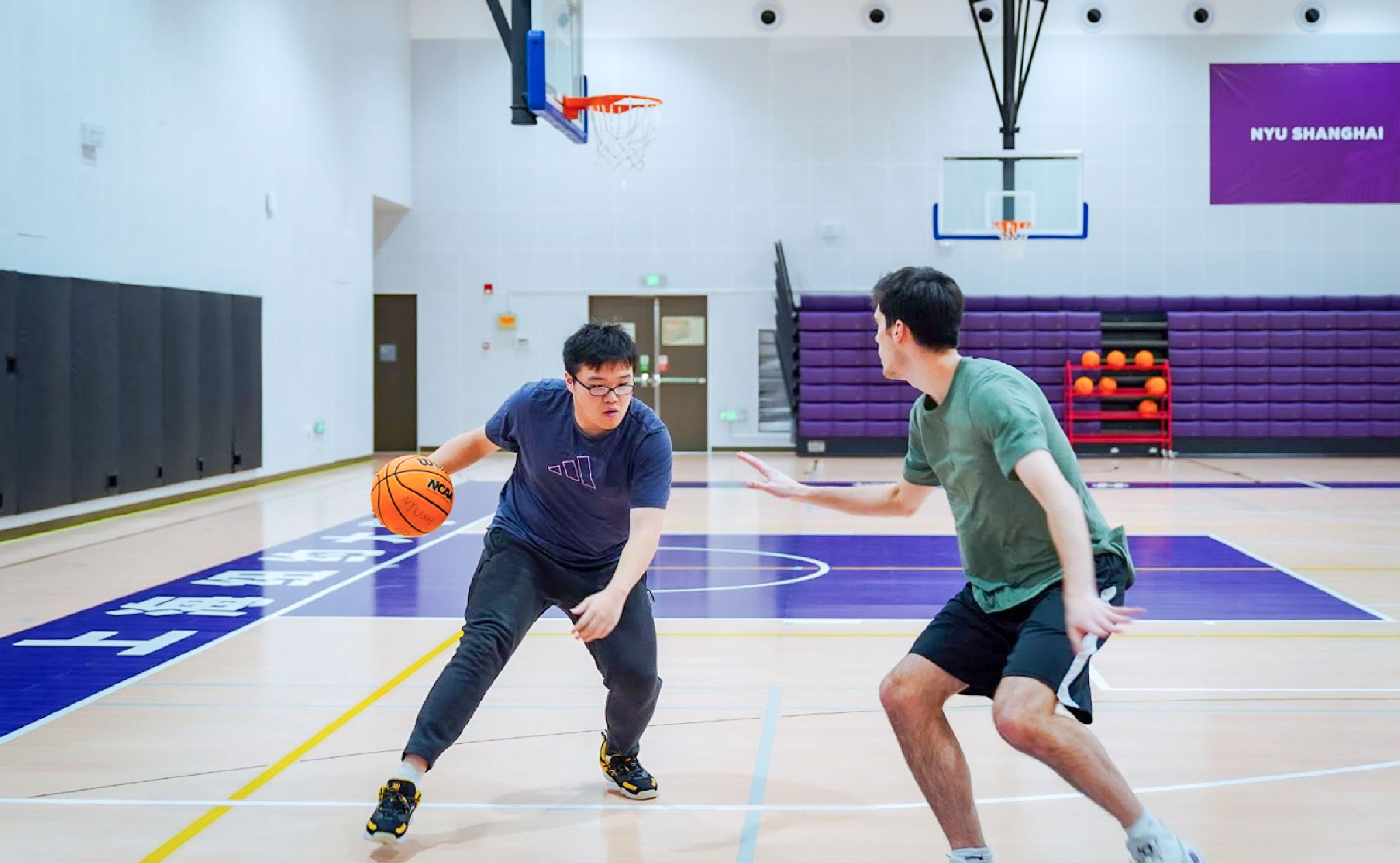 two students playing basketball