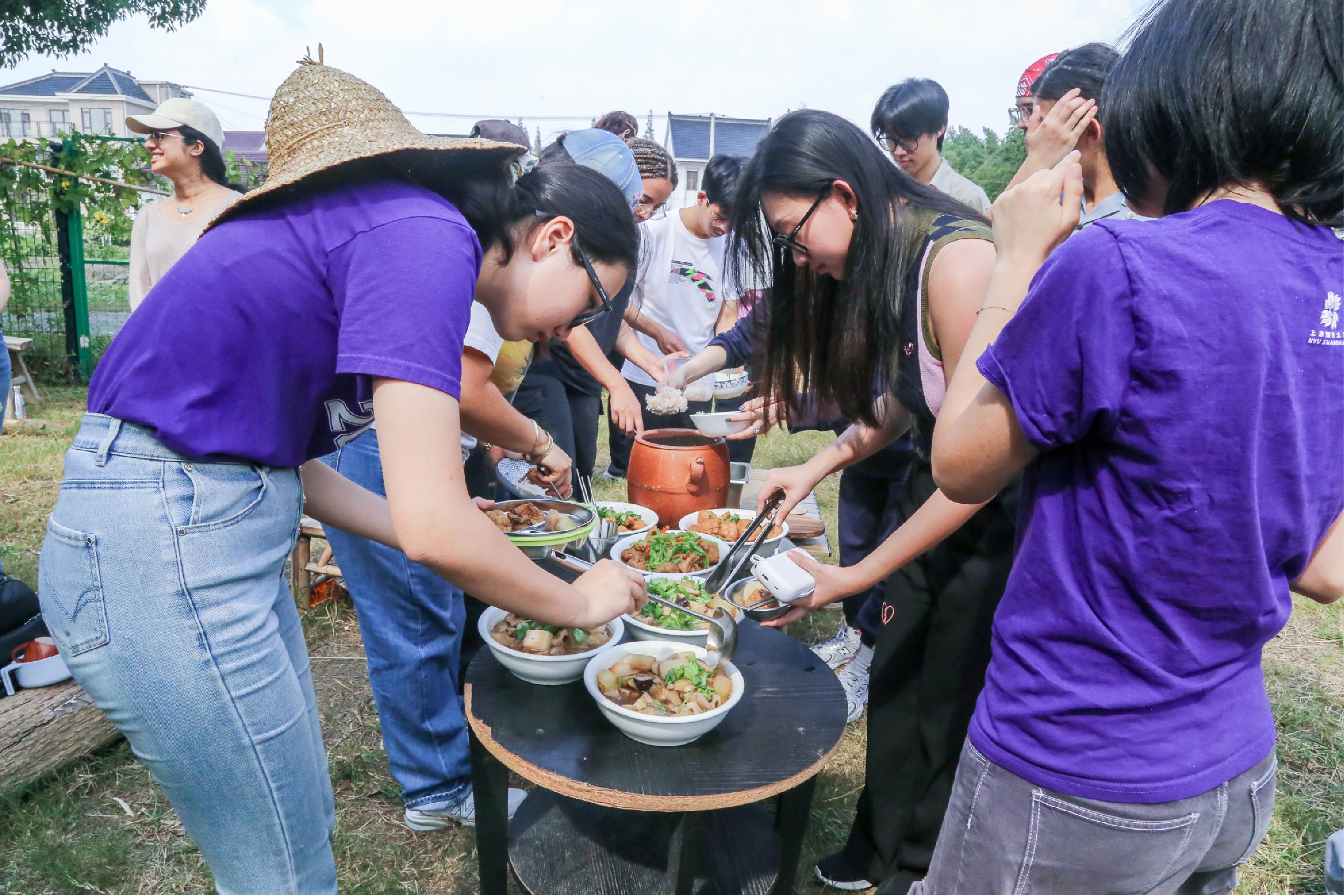 Multiple people gathered around bowls of food for lunch.