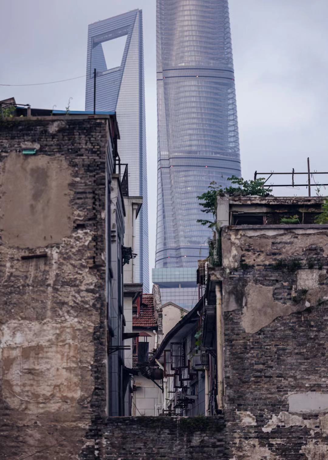 Skyscrapers tower over crumbling brick lane houses