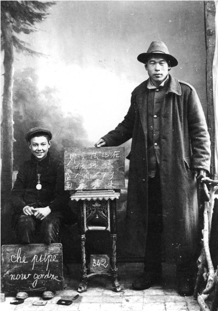 Chinese worker and young European boy pose together in portrait studio