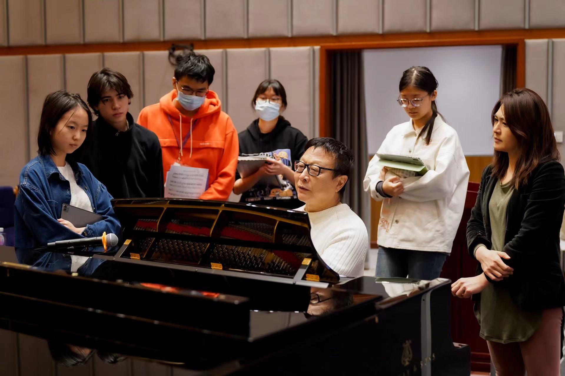 Students gather around Sheng at the Piano