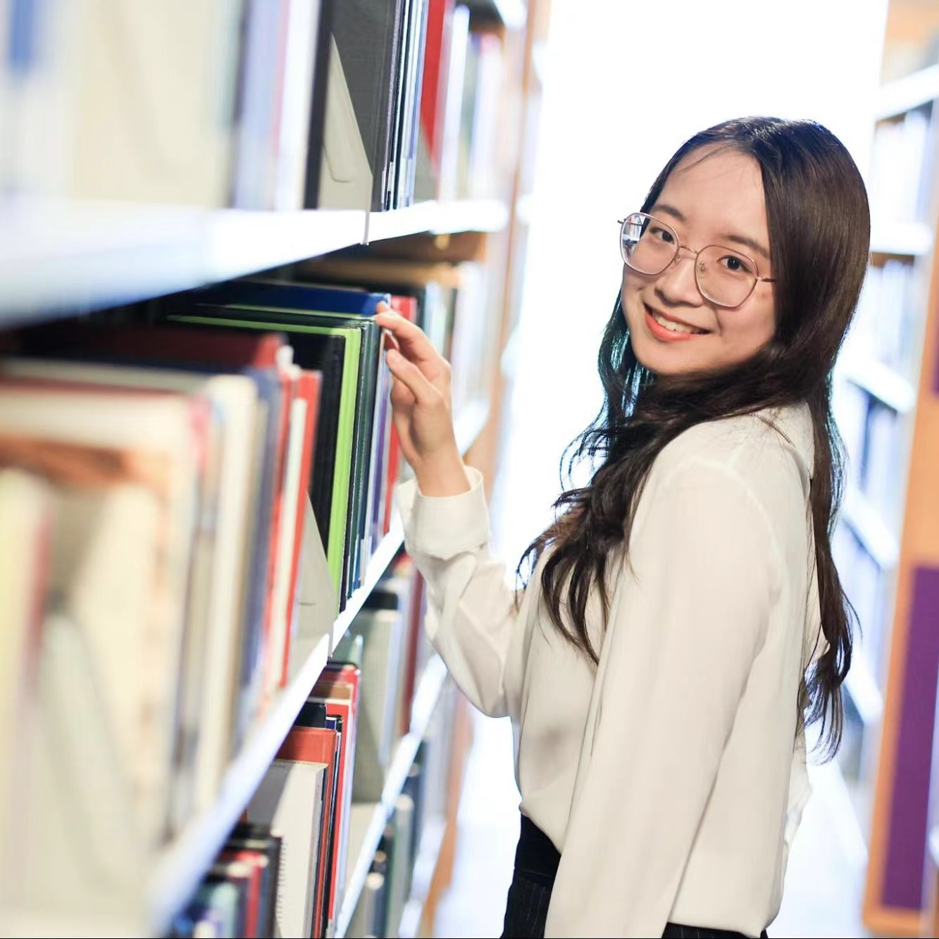 Deng Kexin standing in the stacks of the NYU Shanghai library