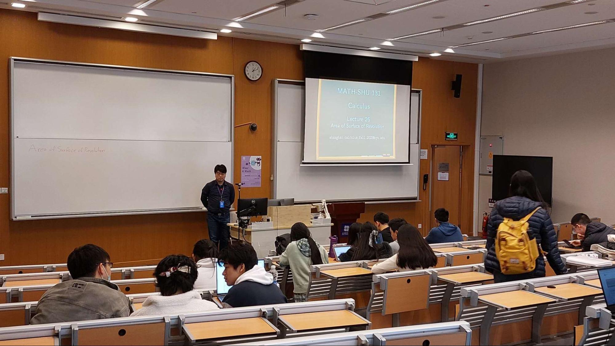 Eric standing at the front of the room of his calculus class lecture. 