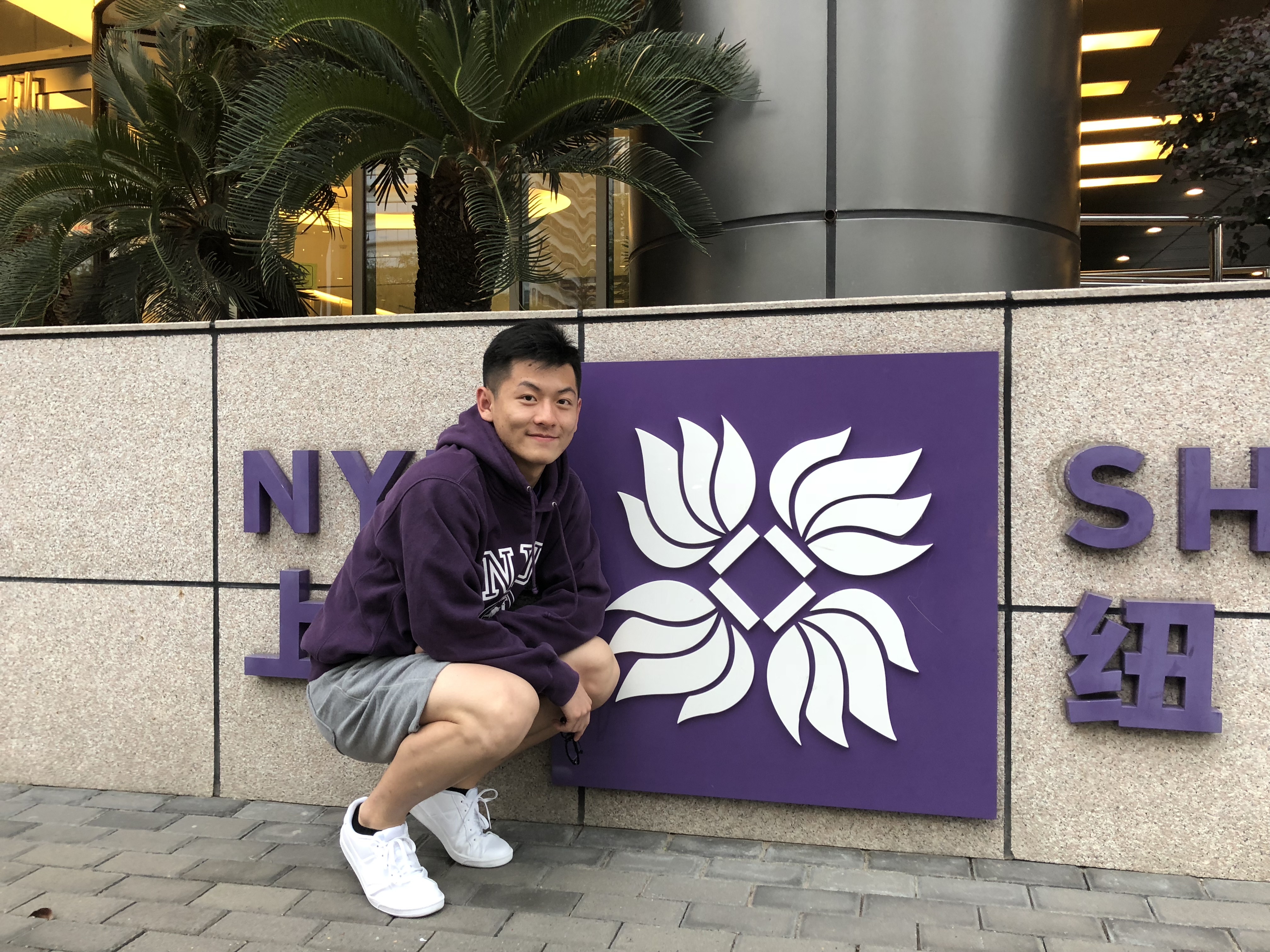 Cai in front of the NYU Shanghai sign on Century Ave during his first semester. 