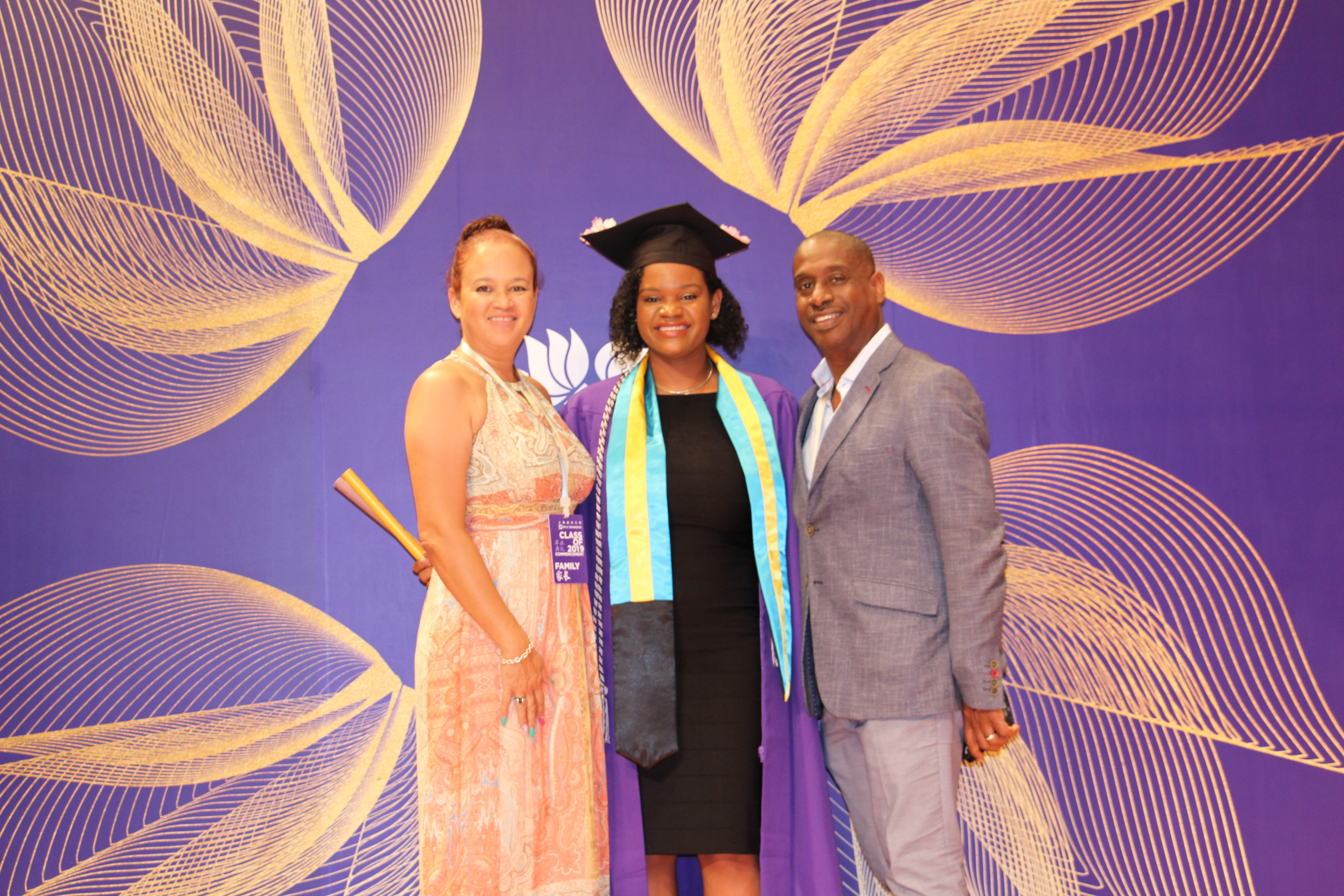 Glinton poses with her parents in NYU Shanghai graduation robes