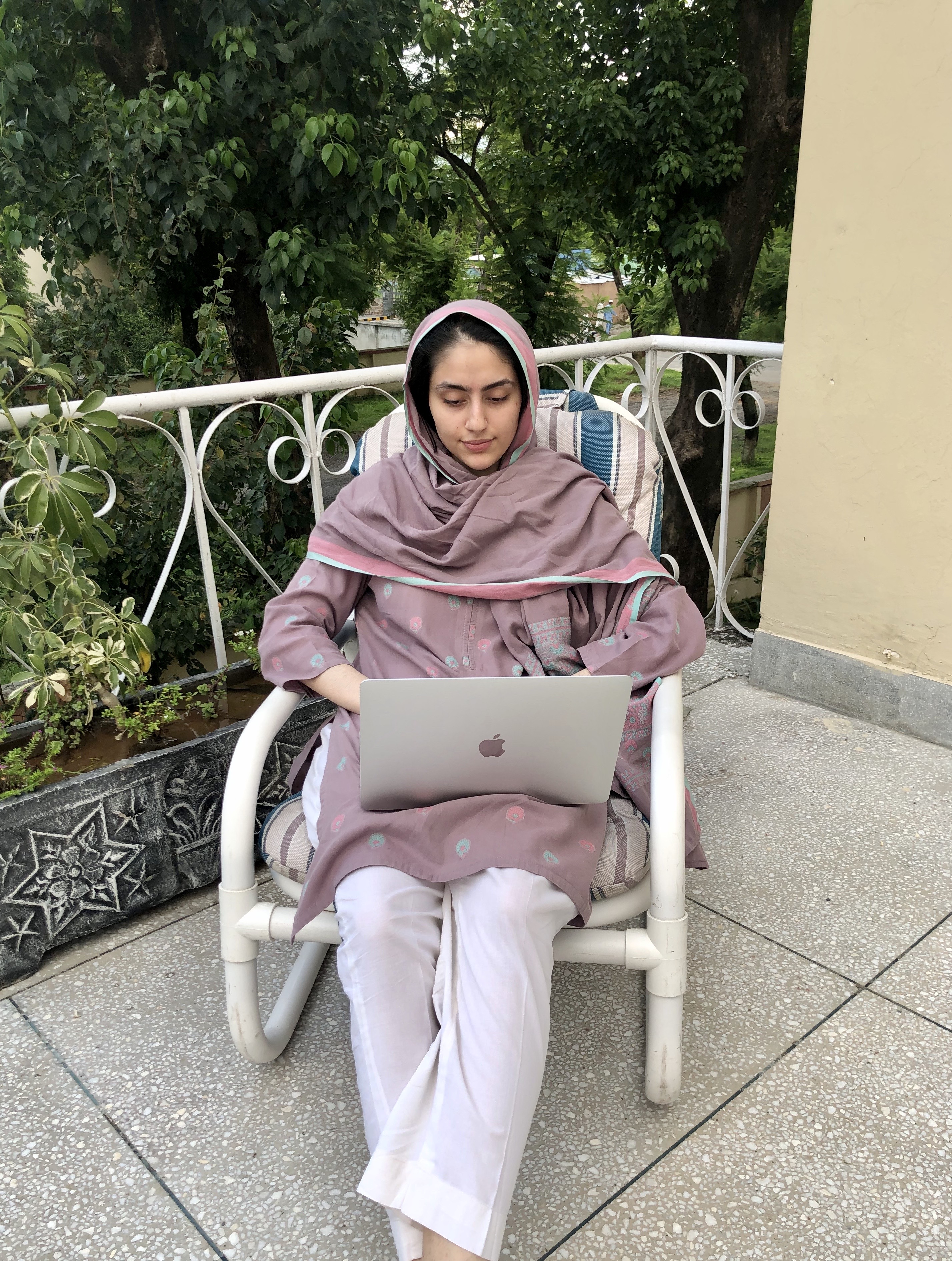 Farheen Foad ’22 sits outside, working on her computer for her remote internship