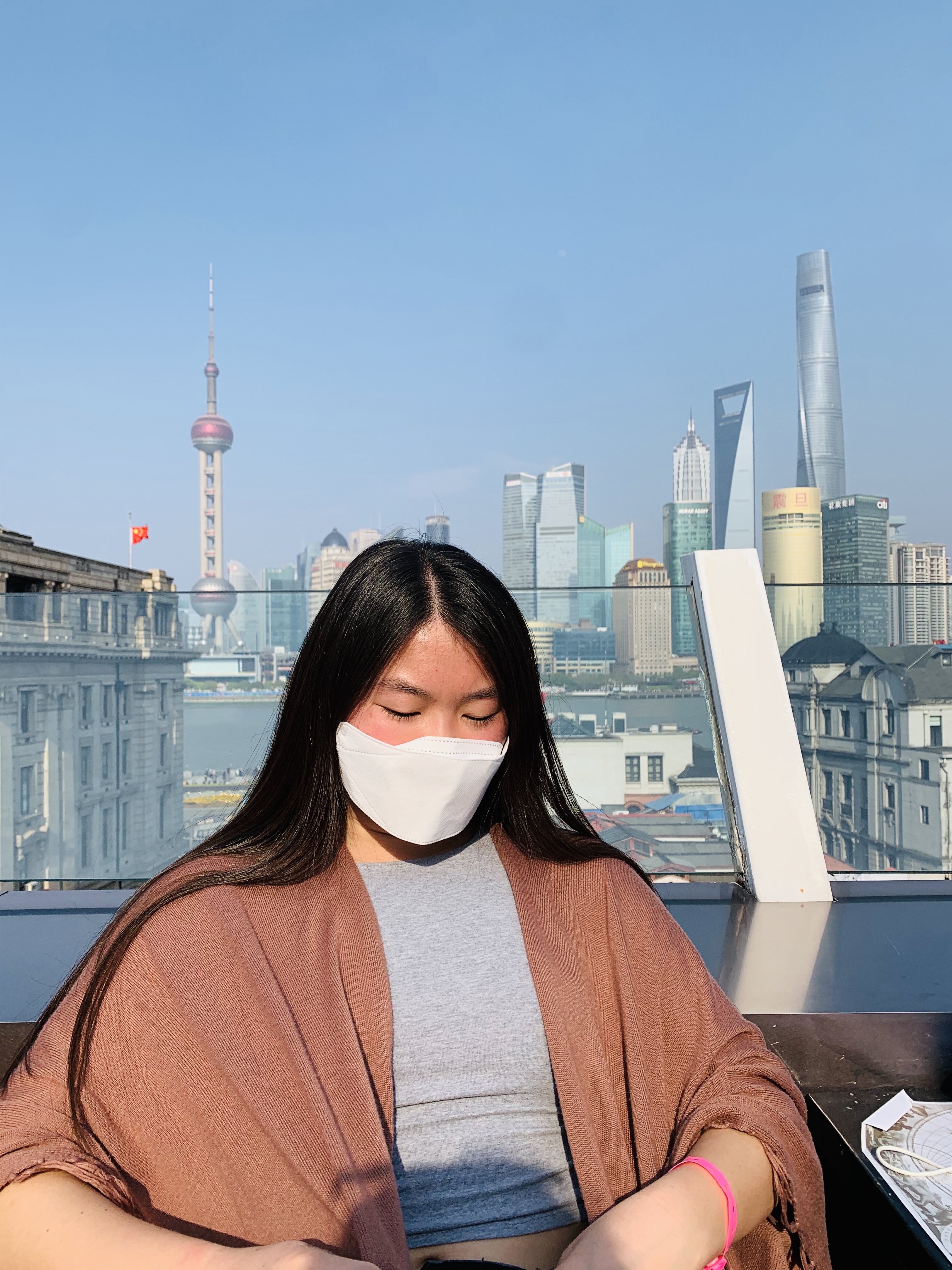 Masked in front of the Pudong skyline