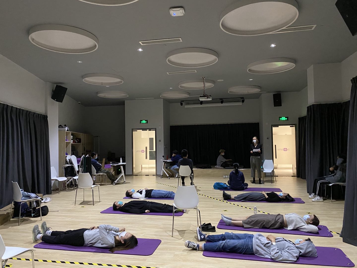 Students meditating on chairs and yoga mats