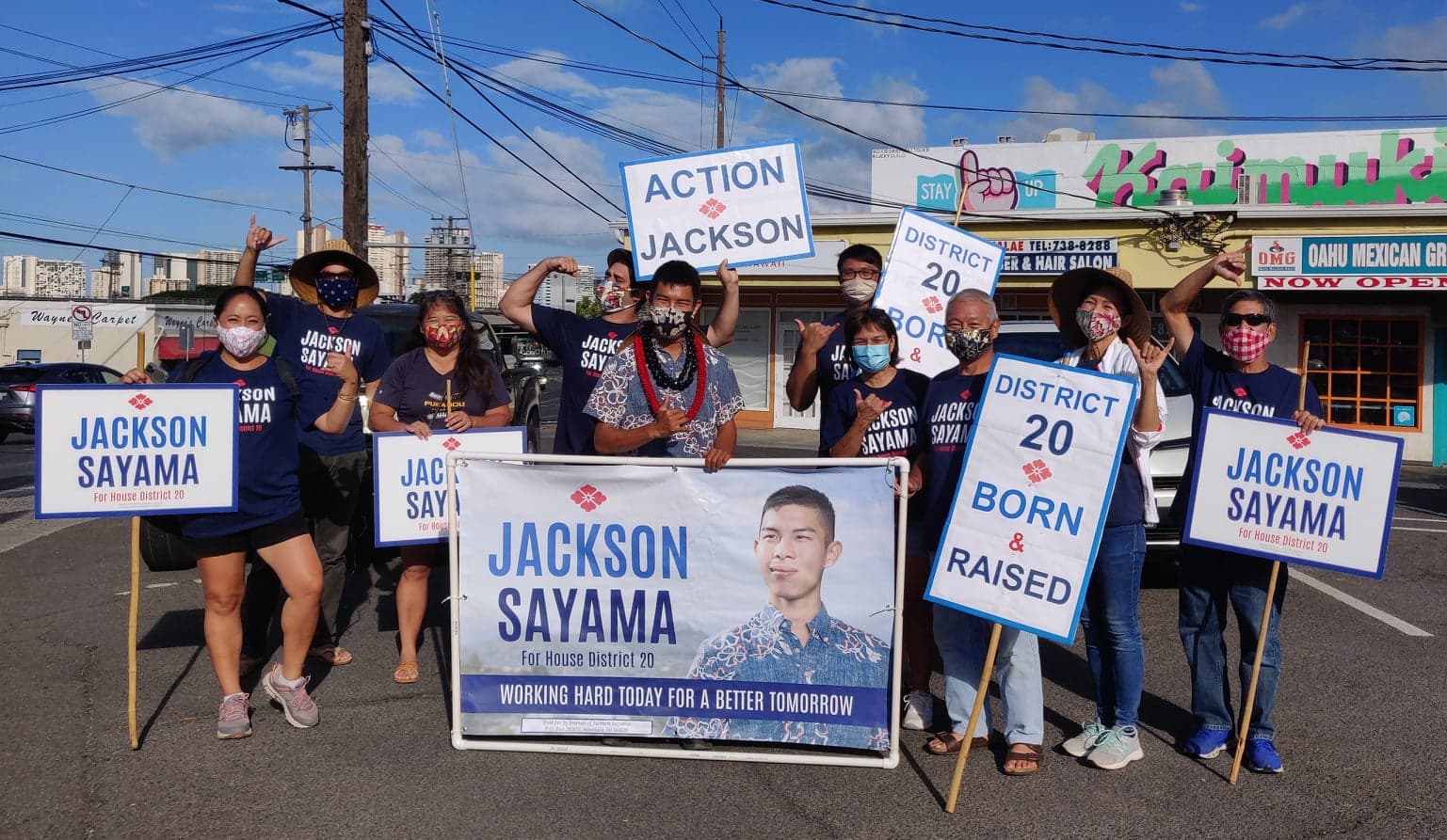 Sayama and his campaign team sign-waving on a sidewalk in Honolulu 