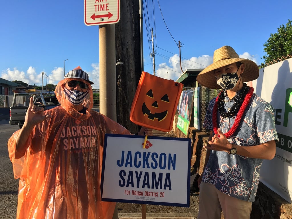 Sayama and his uncle waving campaign signs. 