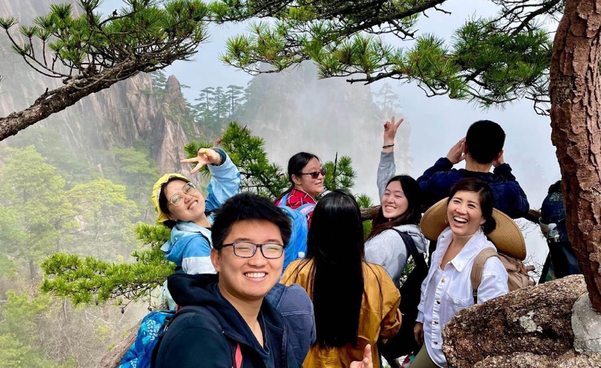 A photo of Jiawen and his classmates posing in front of the mountains