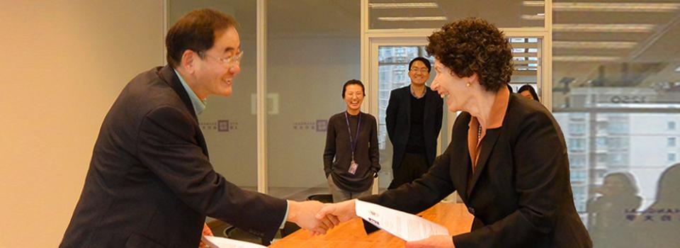 Professor Joanna Waley-Cohen, Provost for NYU Shanghai and Professor Jin Guangyao shake hands