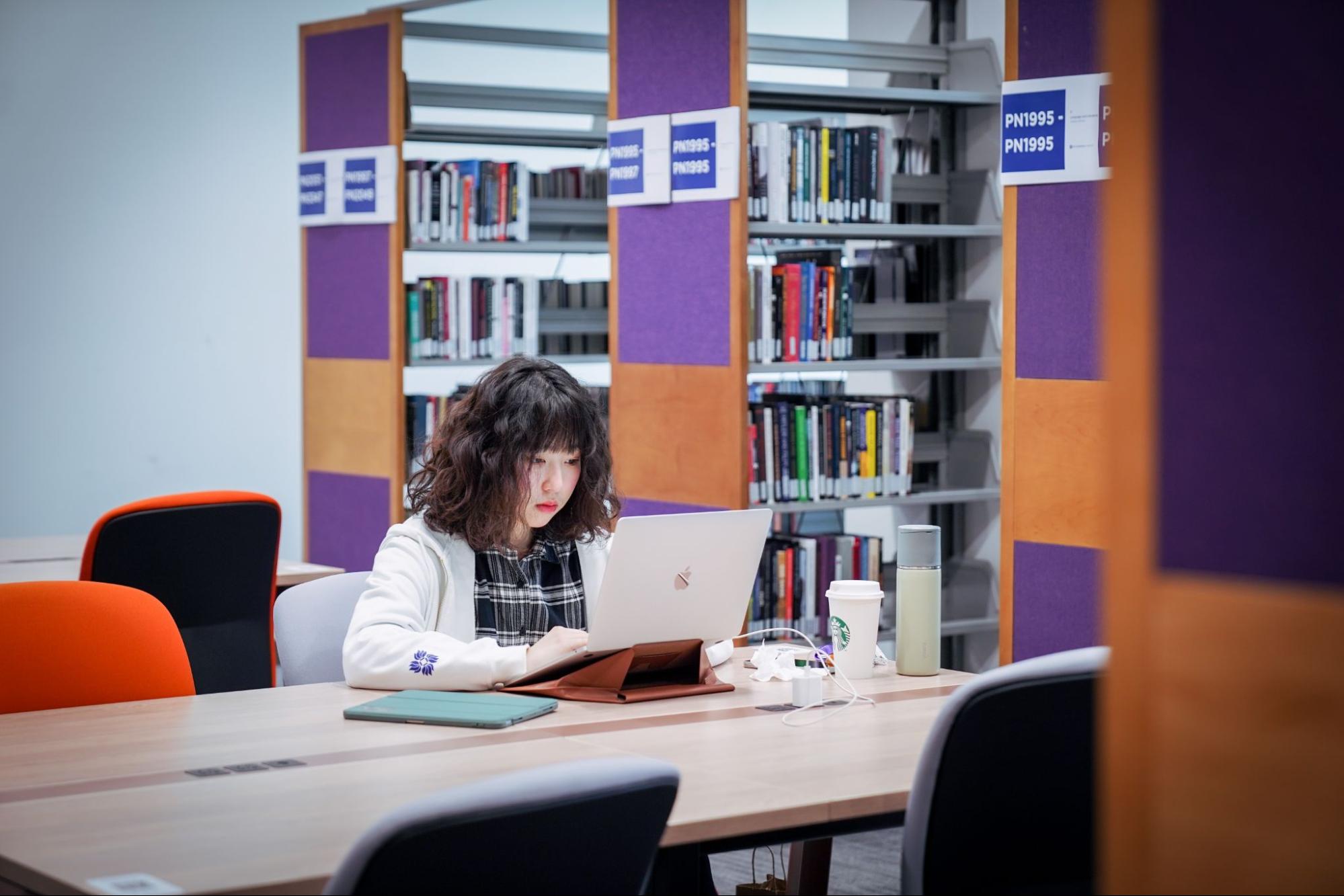 A student sitting at a table in the quiet section of the library. 