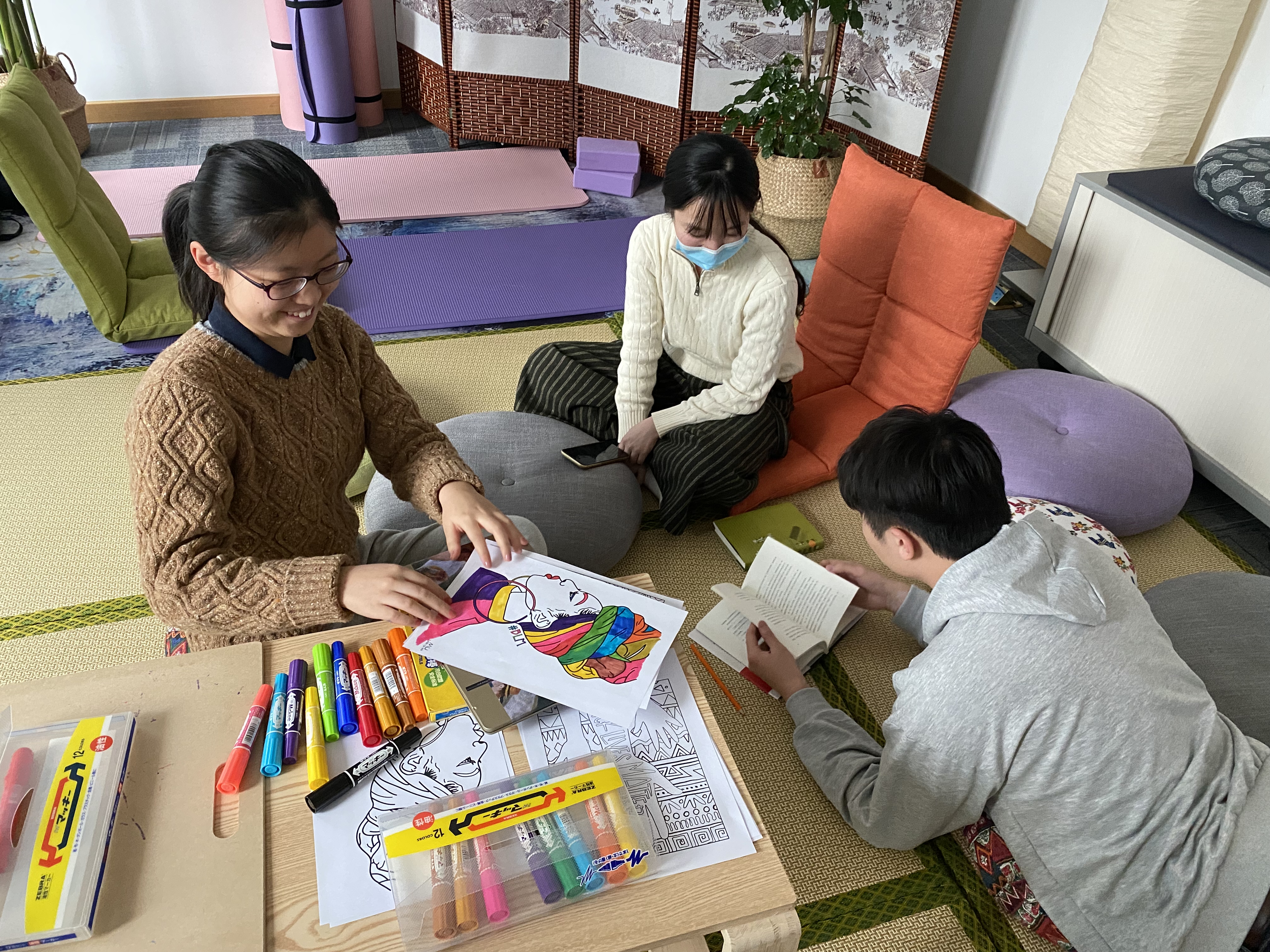 Students sit in a circle doing art and relaxing 