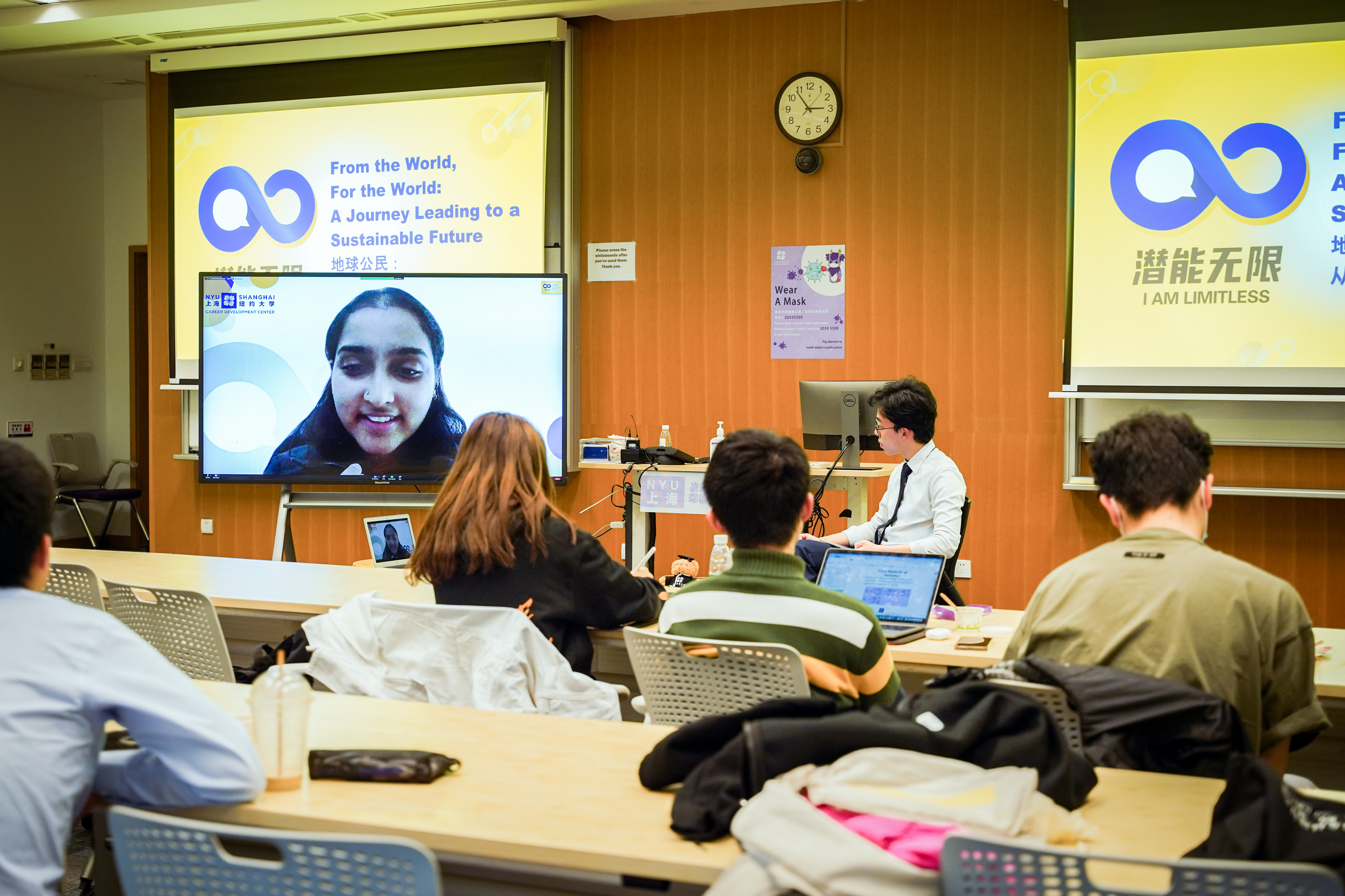 students sit and watch a zoom presenter