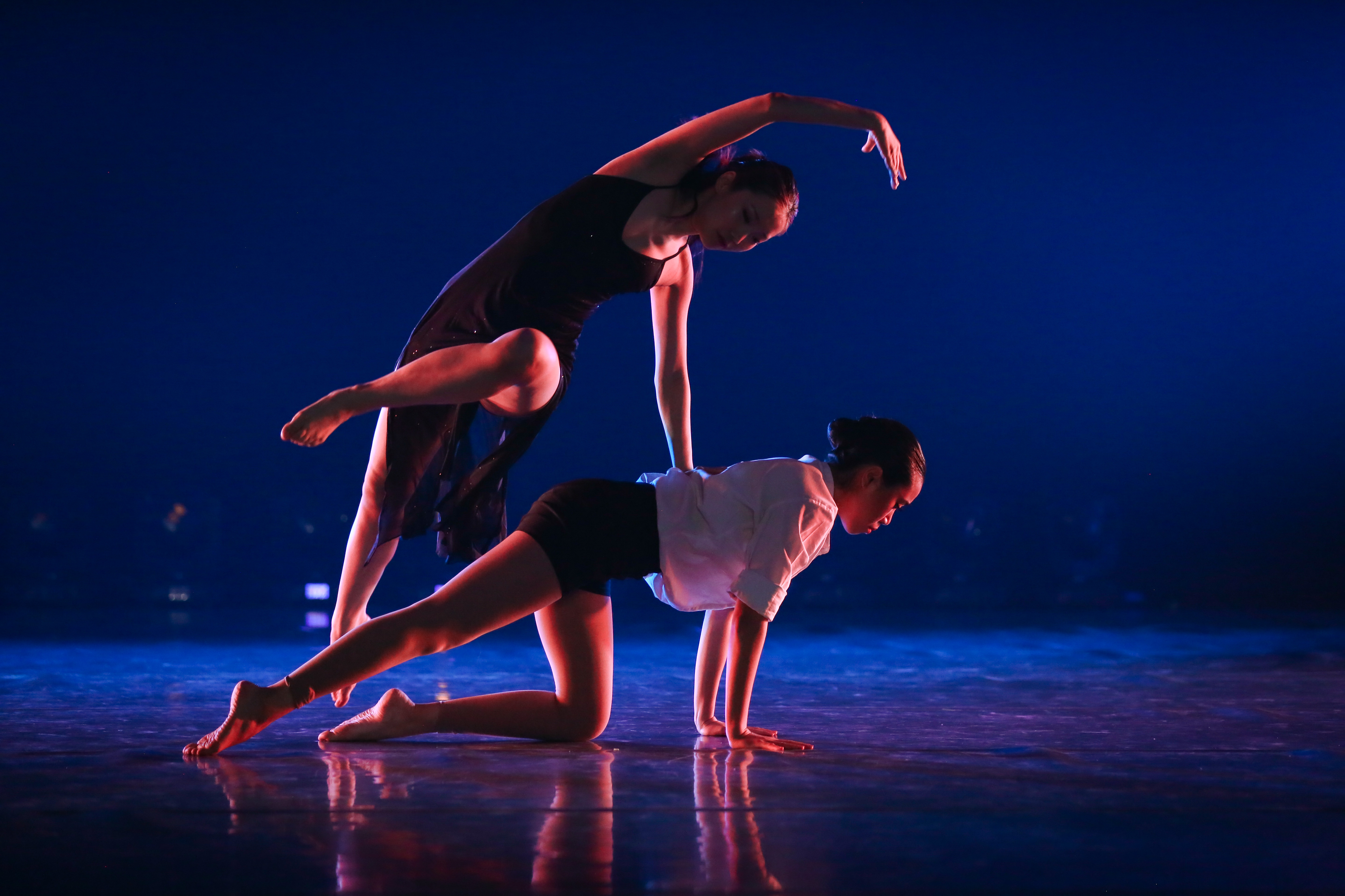 Two dancers strike a pose in dramatic lighting