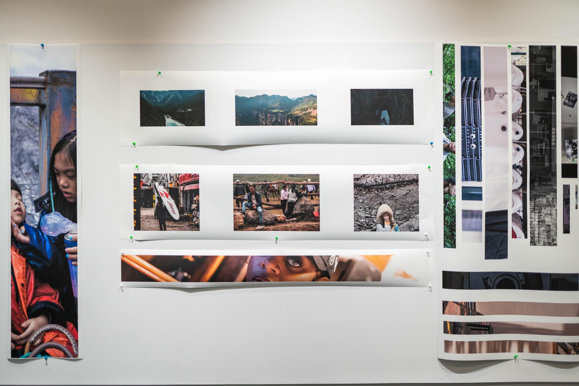 A wall with strips of printed images tacked on