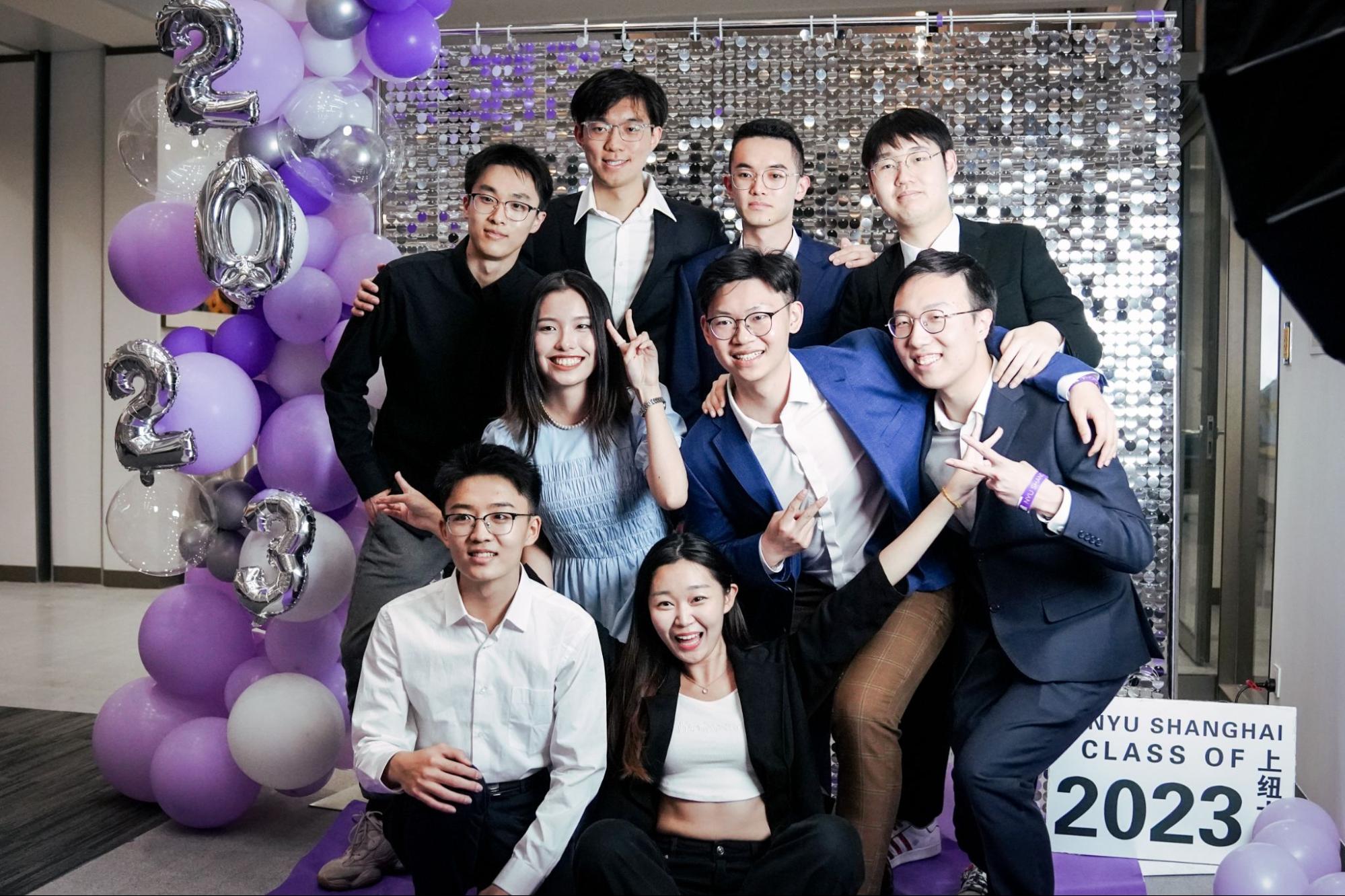 a group of students posing on the purple carpet with friends before the ceremony