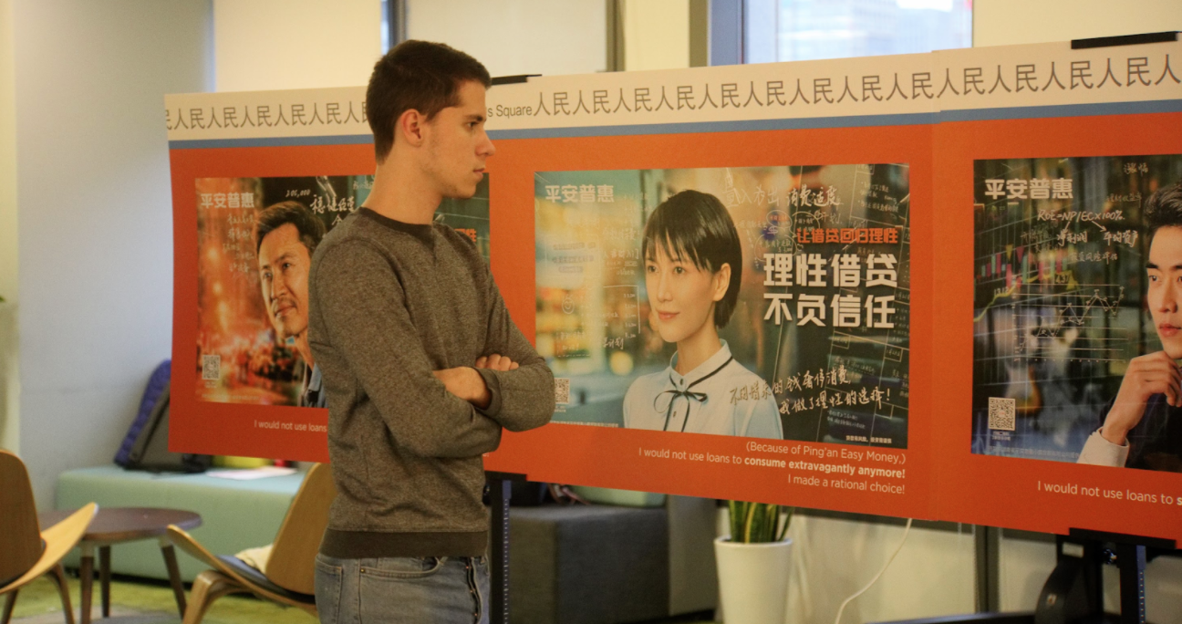 Student looks at poster presenting marketing images