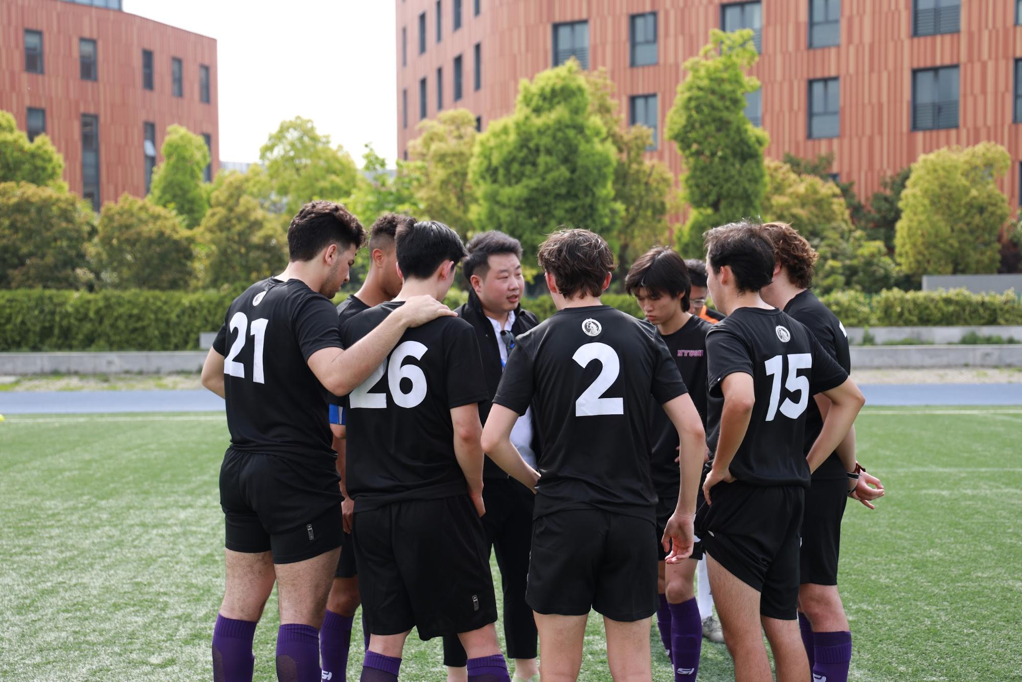 A team of soccer players huddled together on the field