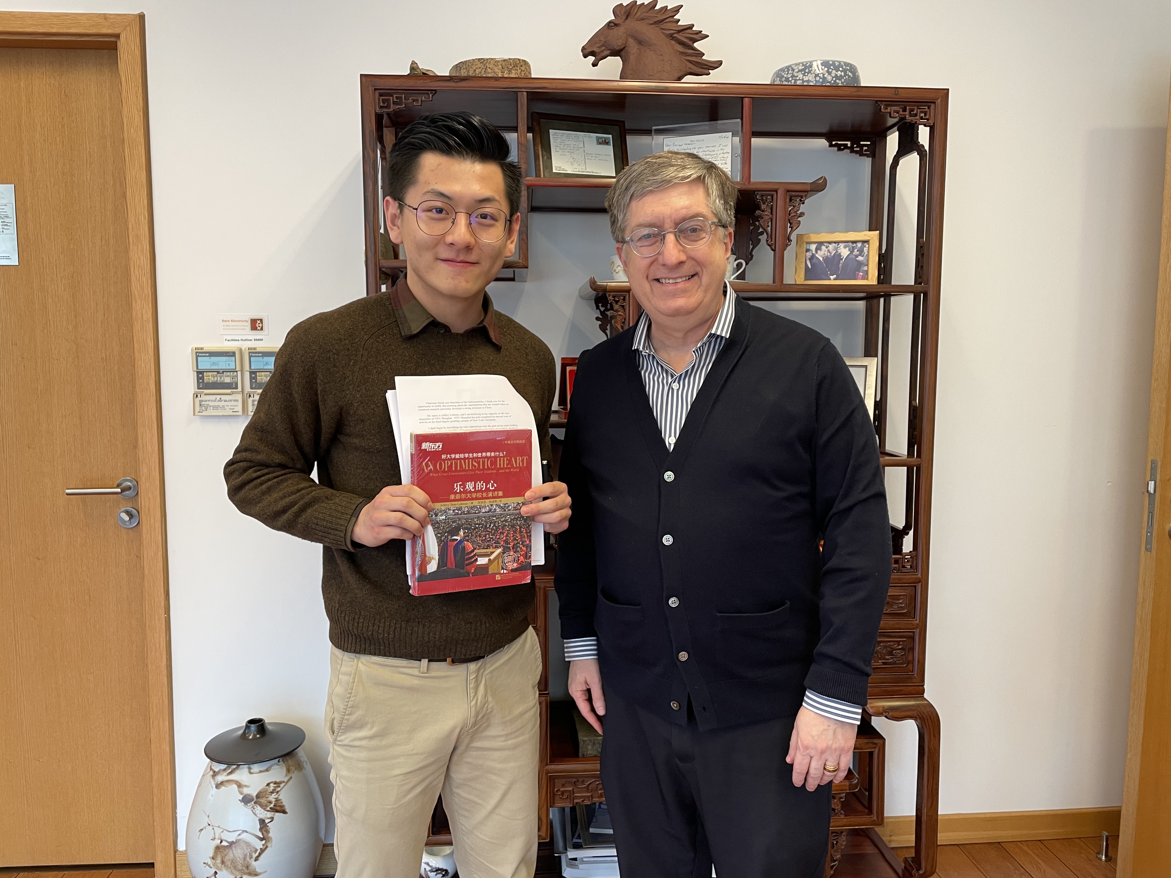 Cai and Vice Chancellor Lehman stand together holding a book. 