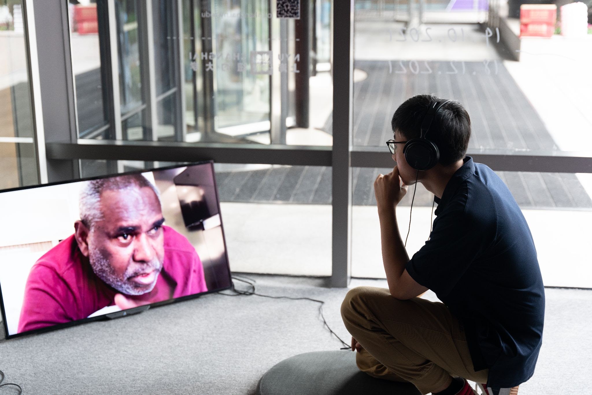 Student listens intently to film using headphones