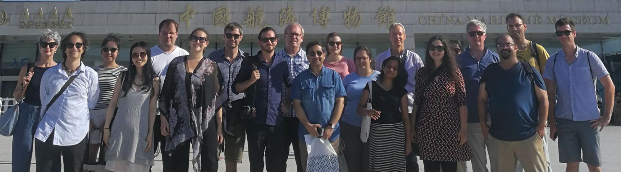 Participants of the 2018 summer school stand lined up, smiling in front of a museum in Shanghai 