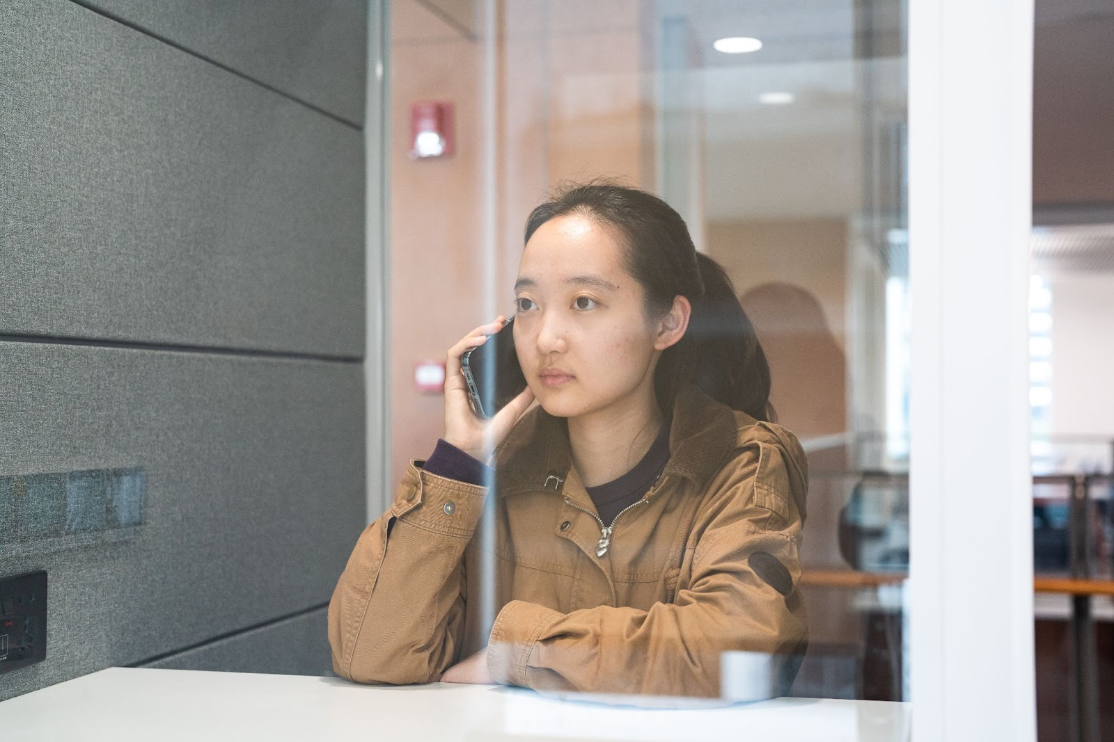 student using phone booth in library