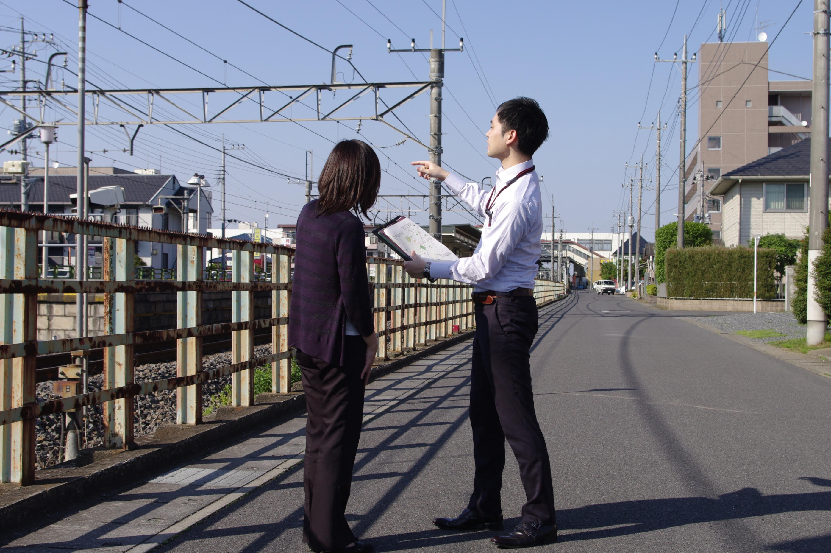 Haginoya discussing the environment of a crime site with an investigator in Japan