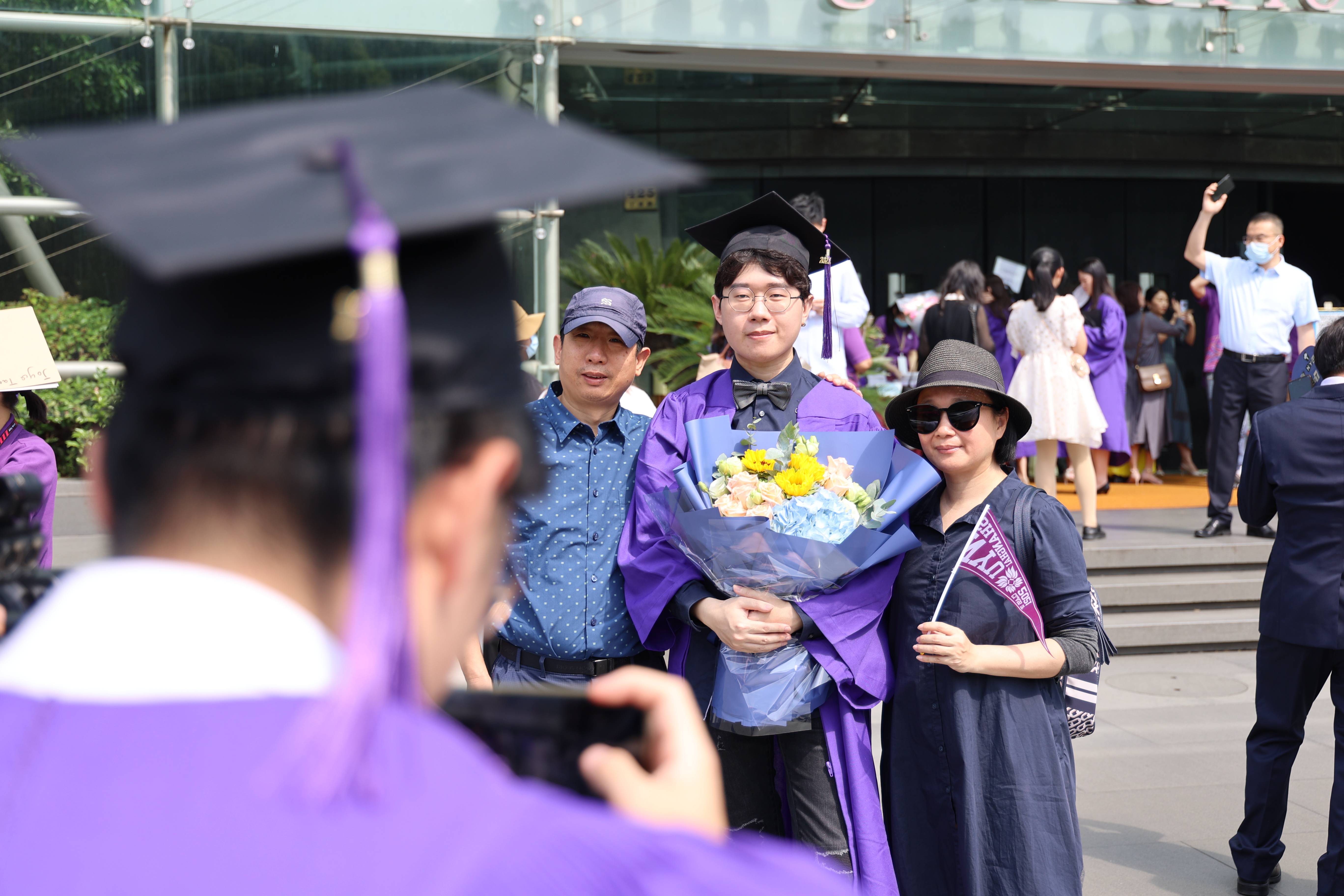 Grad takes photo of classmate posing with his parents