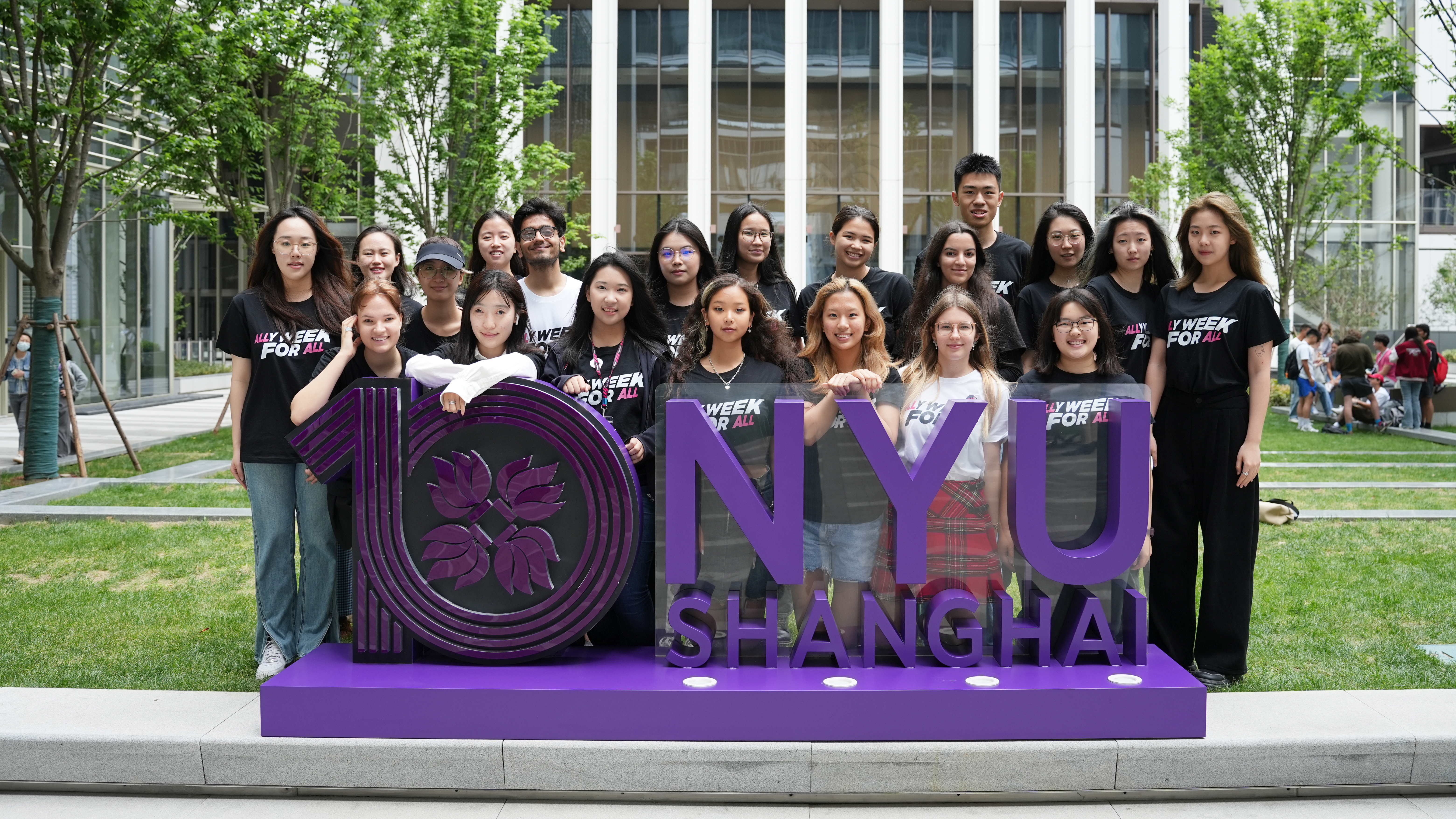 Students wearing "Ally Week for All" shirts pose with an NYU Shanghai sign