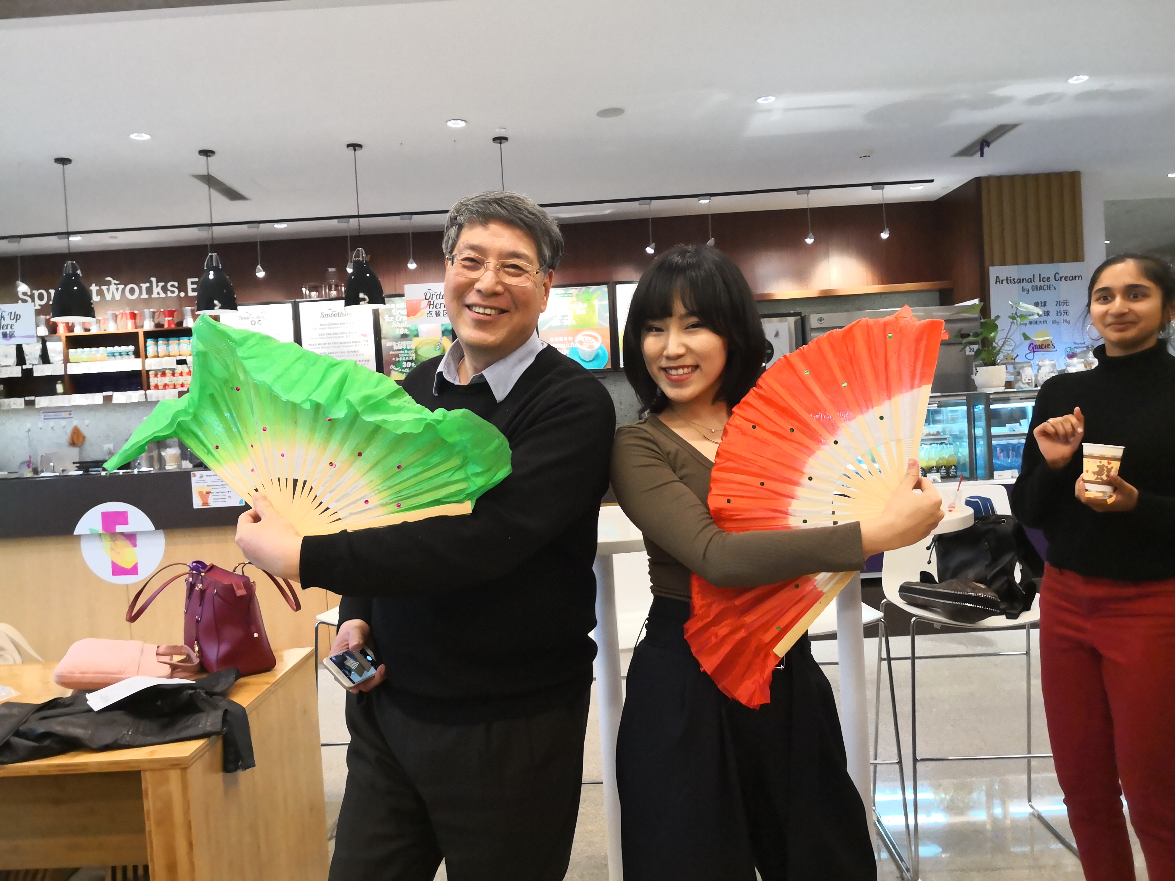 Yu and student wave colorful fans 