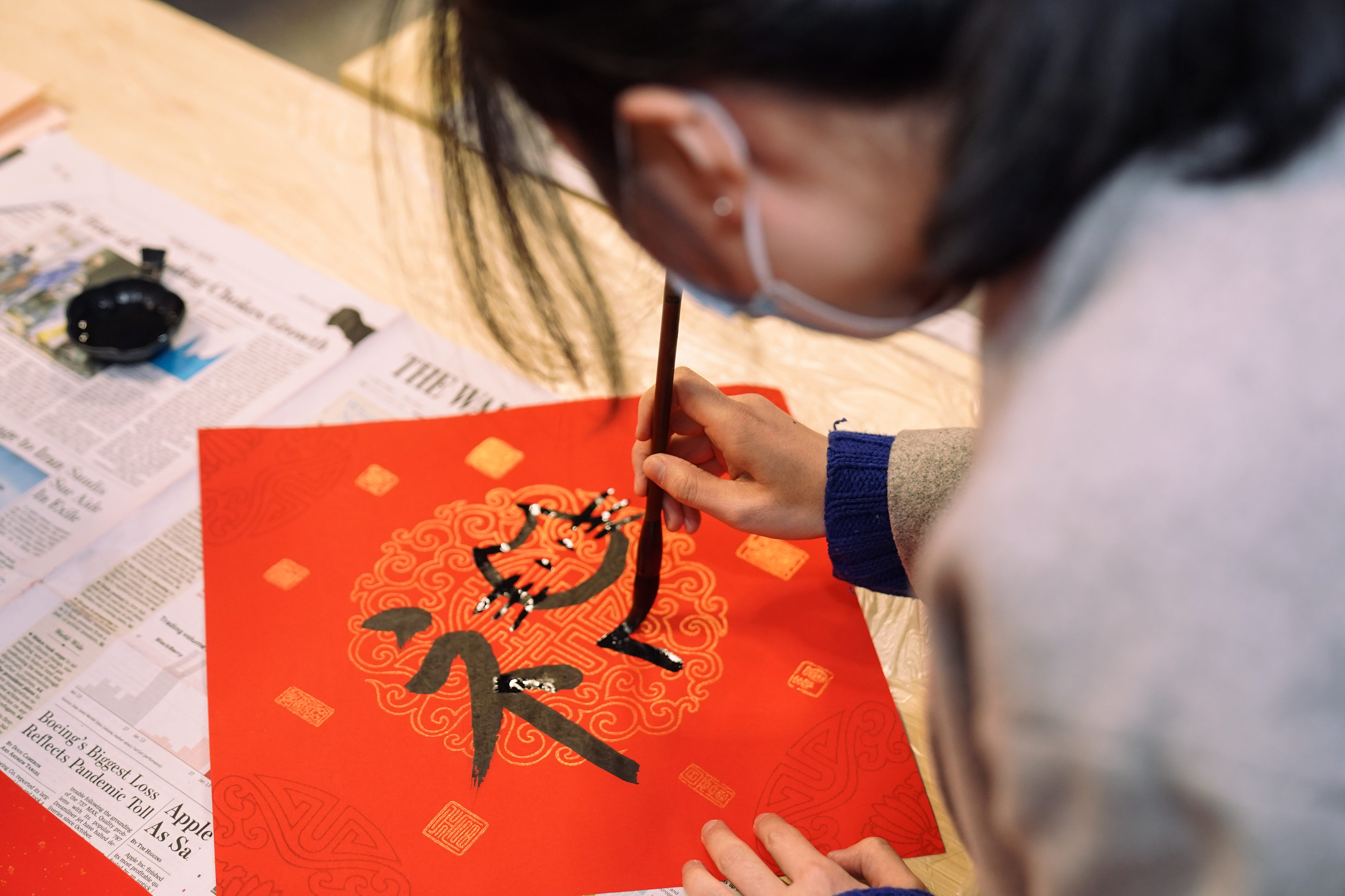 Student uses brush to write character with cat face