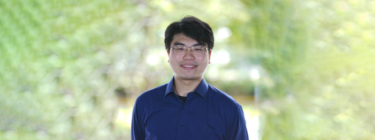 a headshot of eric with a green background