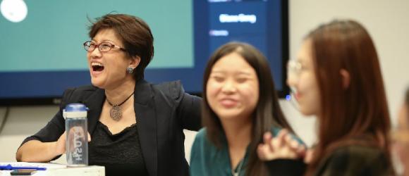 Wen Shuang and her students sit and laugh in the audience. 