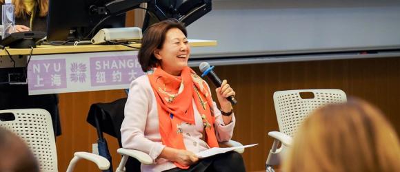 Hua Jiang smiling and holding a microphone