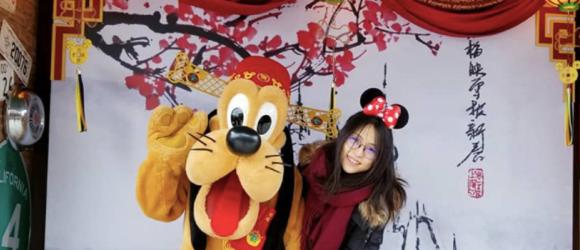 A student posing for a photo with Goofy
