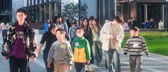 students and children walk together on campus 