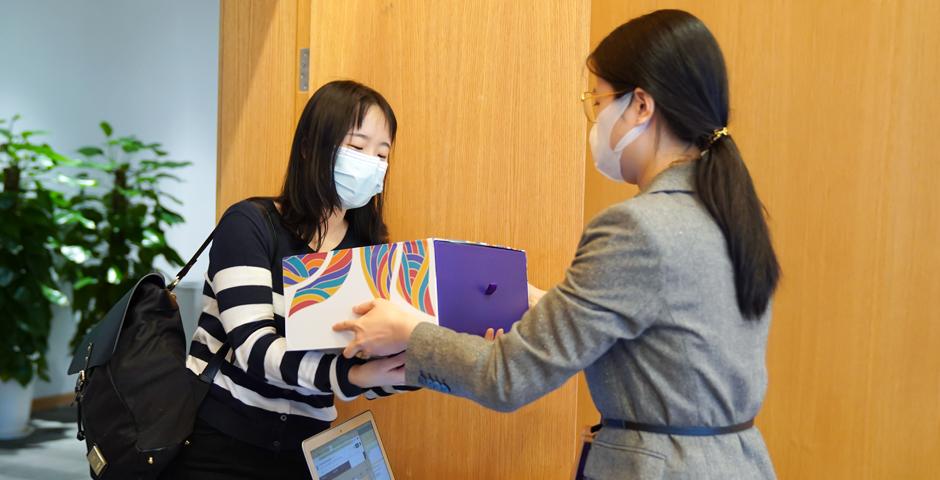 5月8日，一位大四学生从员工手中接过毕业礼盒。