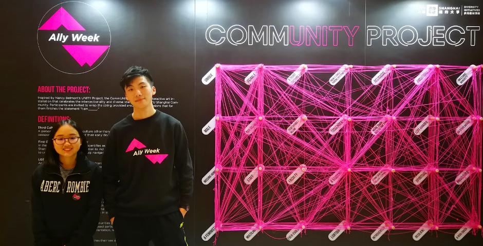 2022届Maggie Xiao Liang和2023届Nigel Lu站在“Ally Week社群项目”展板前。150名多上海纽约大学的成员参加了这项活动，从独特的、有宗教信仰的、顺性别、教师、性格内向、LGBTQIA +、第三文化儿童等特质中选出与自己匹配的，并用线加以联结，共同创建属于上纽大的互动式身份地图。
