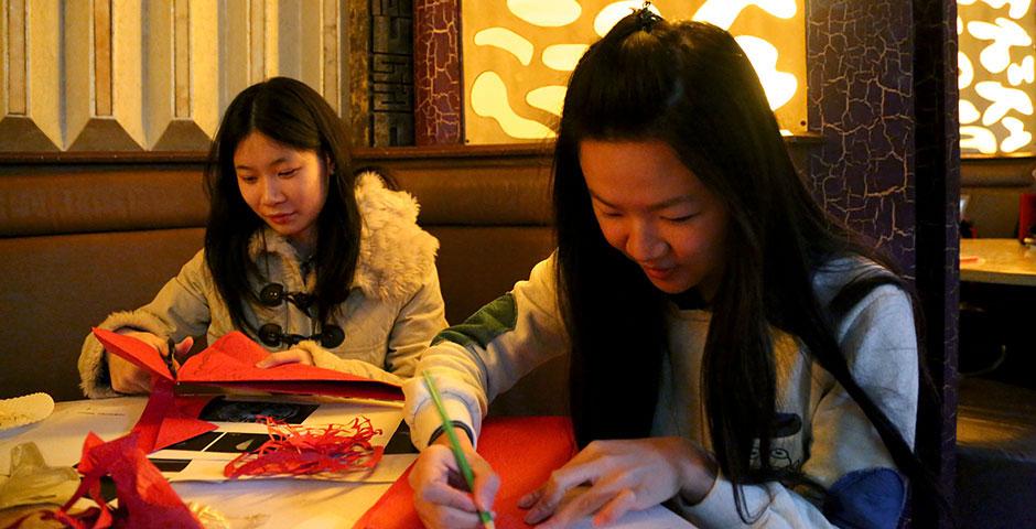 Students prepare for the upcoming Spring Festival holiday by creating traditional Chinese paper cuttings. February 1, 2015. (Photo by Annie Seaman)