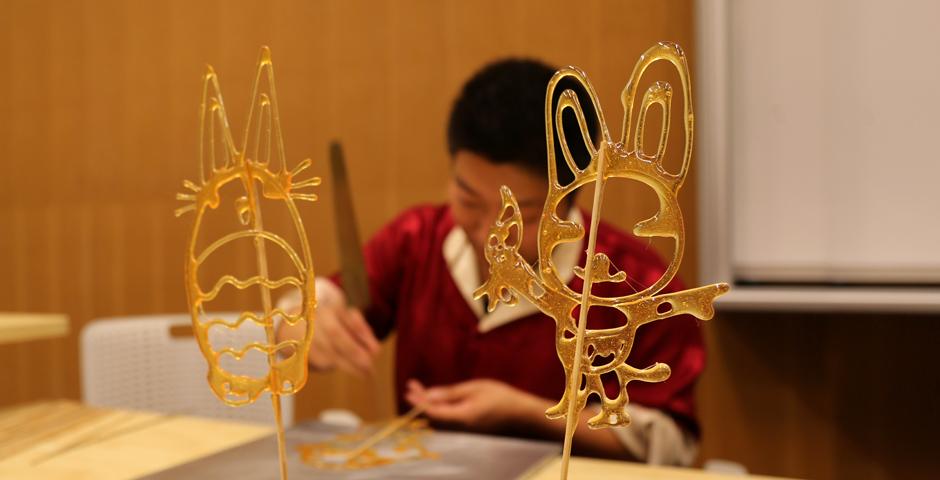NYU Shanghai students learned the Chinese folk art of sugar painting, a craft which uses melted sugar to create traditional animal and plant figures. Two Shanghainese sugar artists instructed students at the October 26 event. (Photo by: Wenqian Hu)