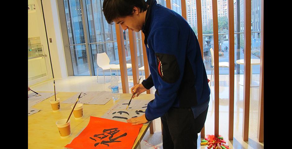 上海纽约大学学生庆祝中国新年，外国学生学习中国传统文化，与中国学生一起参与剪纸、书法、名族舞以及中国传统游戏。（摄影：NYU Shanghai）
