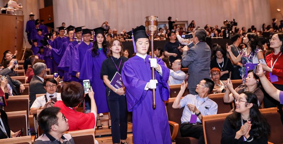 Lewis Liu bears the NYU Shanghai torch into the ceremony hall.