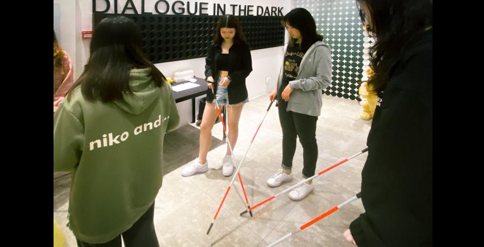 At Dialogue in the Dark (黑暗中对话), 31 students and one staff member were led through a simulation of  visual impairment. Equipped with only a cane, the students  were asked to enter and explore a series of pitch black rooms and asked to complete a few tasks of  daily life—crossing a road, walking over different surfaces such as  bridges, grass, and other terrain.
