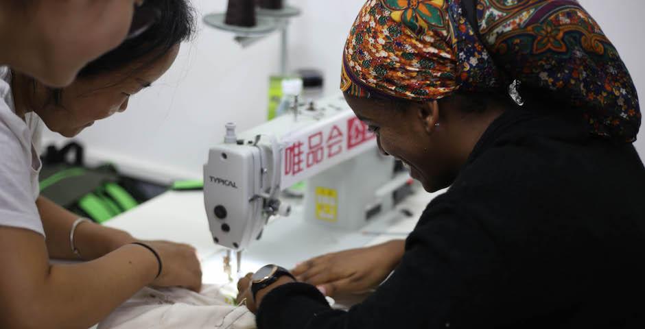 10月2日，上纽大的同学参观了当地一家纺织厂。这家工厂出产印有儿童手绘图案的环保布袋。工厂工人正在教同学们如何缝制布袋。在智行基金会的帮助下，这家工厂为受HIV病毒或艾滋病影响的家庭提供了大量就业机会。（图 纽约大学阿布扎比校园2020届学生Takumi Miyawaki）