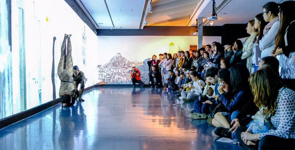 Emma Quong dances with the wall, physically representing sections of Qiu Anxiong’s painted mural. (Photo by: Michael Shi and Charlie Wang)